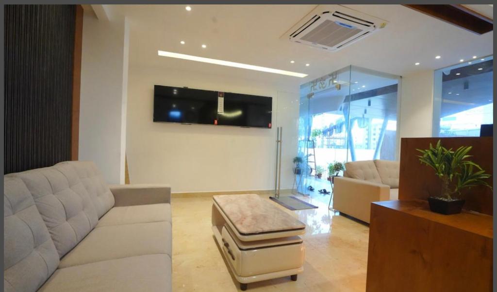 a living room with a white couch and a table at KVP GOLDEN INN in Tirupati