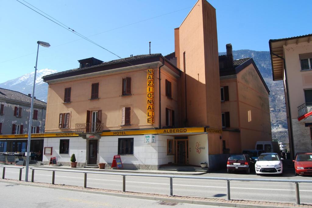 ein Gebäude auf einer Straße mit davor geparkt in der Unterkunft Albergo Nazionale in Biasca