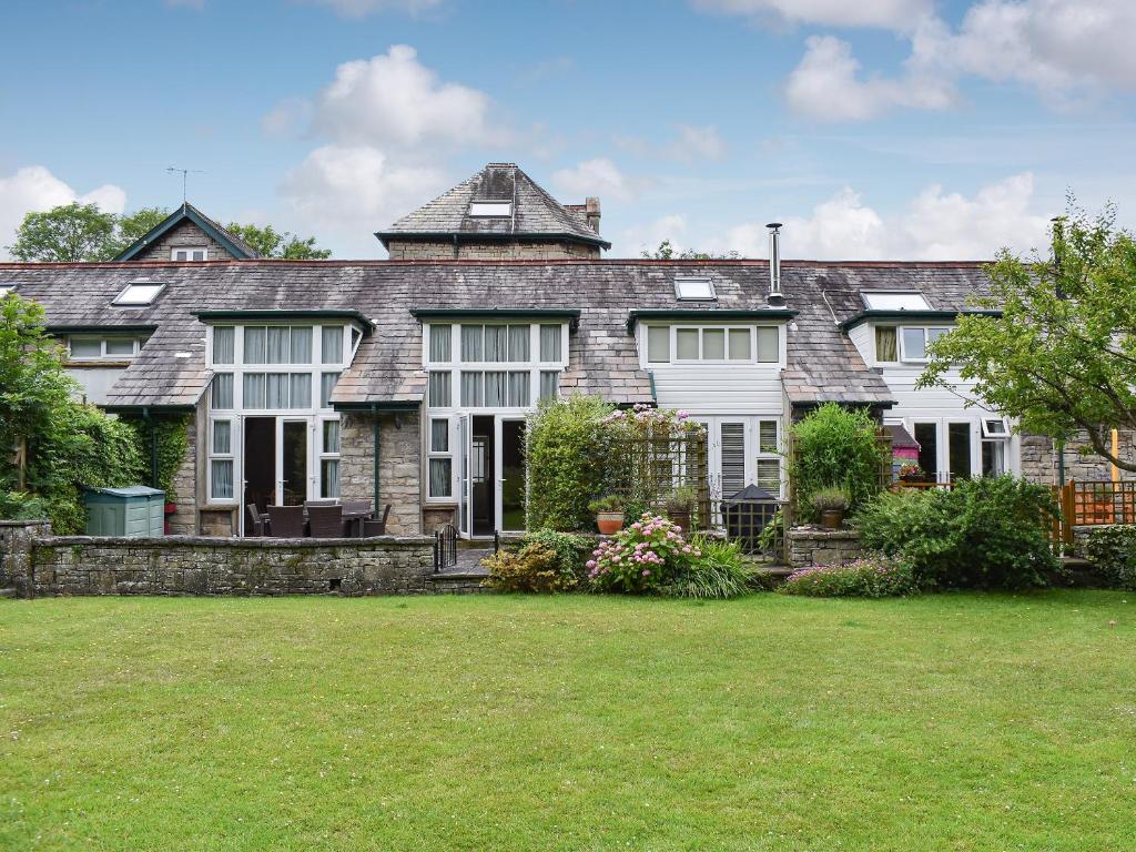 a large stone house with a large yard at Woodland View in Arnside