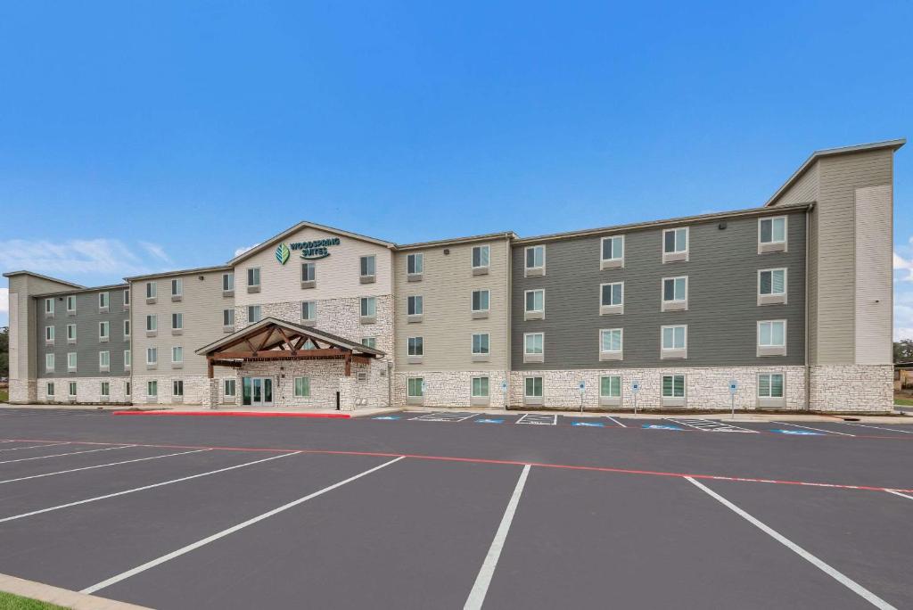 a hotel with a parking lot in front of it at WoodSpring Suites San Antonio UTSA - Medical Center in San Antonio