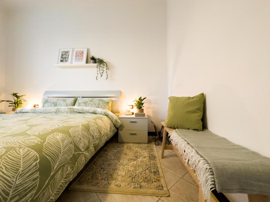 a bedroom with a bed and a bench in it at Litta's flat in Affori - 3 mins walk from MM3 in Milan