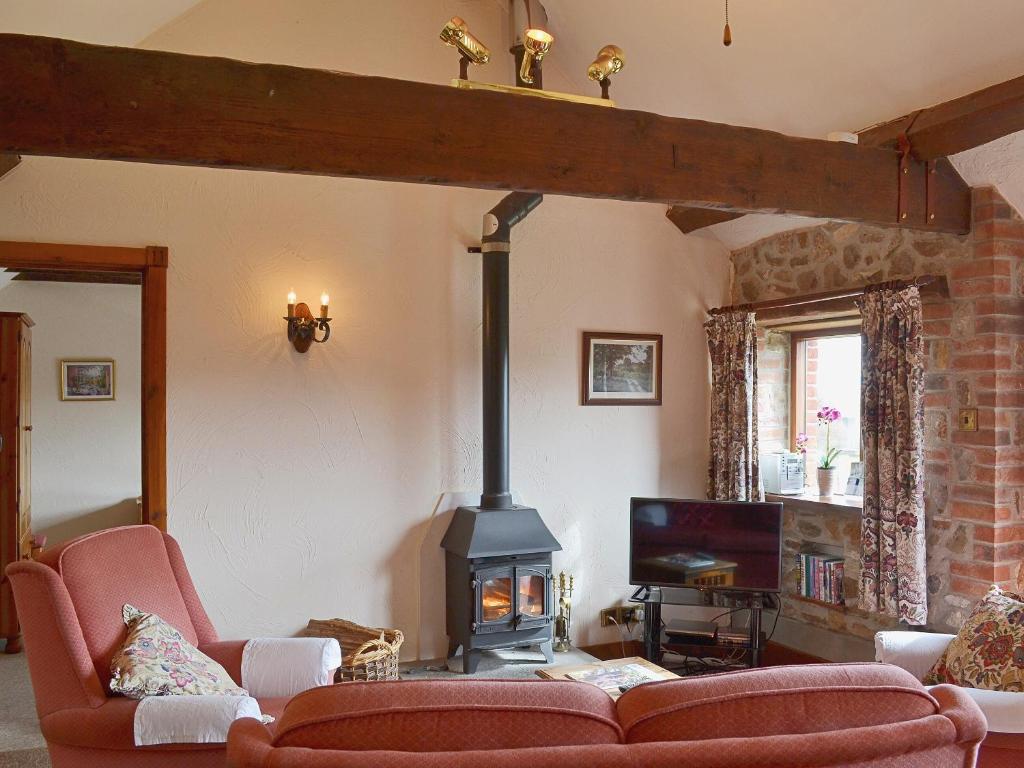 a living room with a fireplace and a couch at Ashley's in Colyton