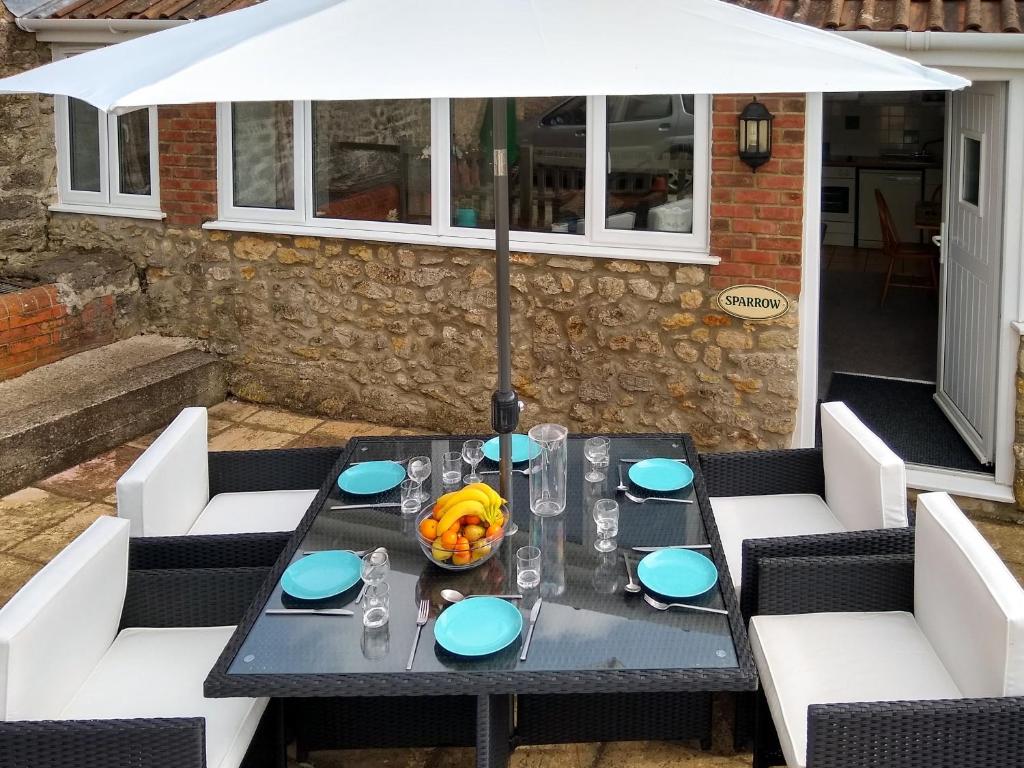 a black table with a white umbrella on a patio at Sparrow in Burton Bradstock