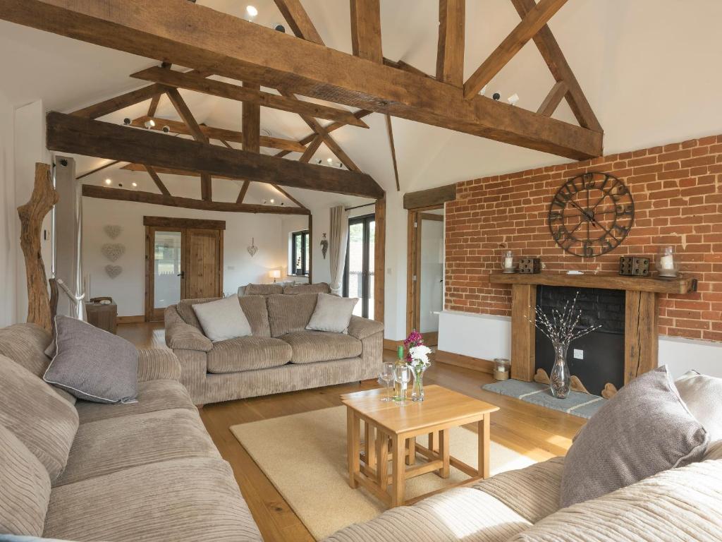 a living room with two couches and a fireplace at Summer House Stables in Catfield