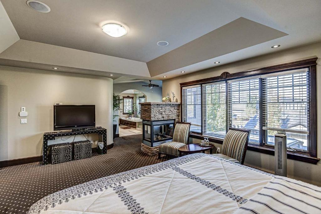 een slaapkamer met een bed en een flatscreen-tv bij Westmount River Inn in Calgary