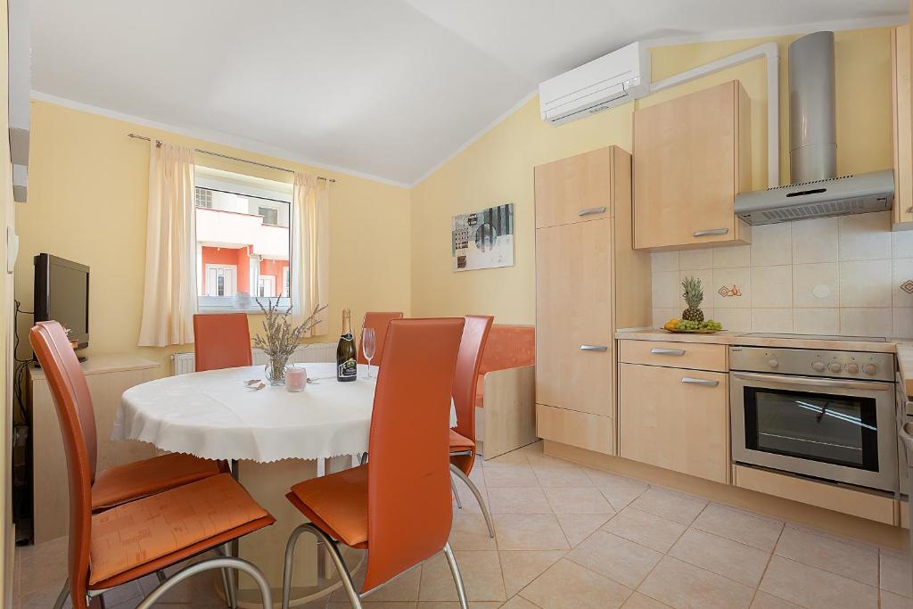 uma cozinha e sala de jantar com mesa e cadeiras em Apartments Ljubica Pulj em Fažana