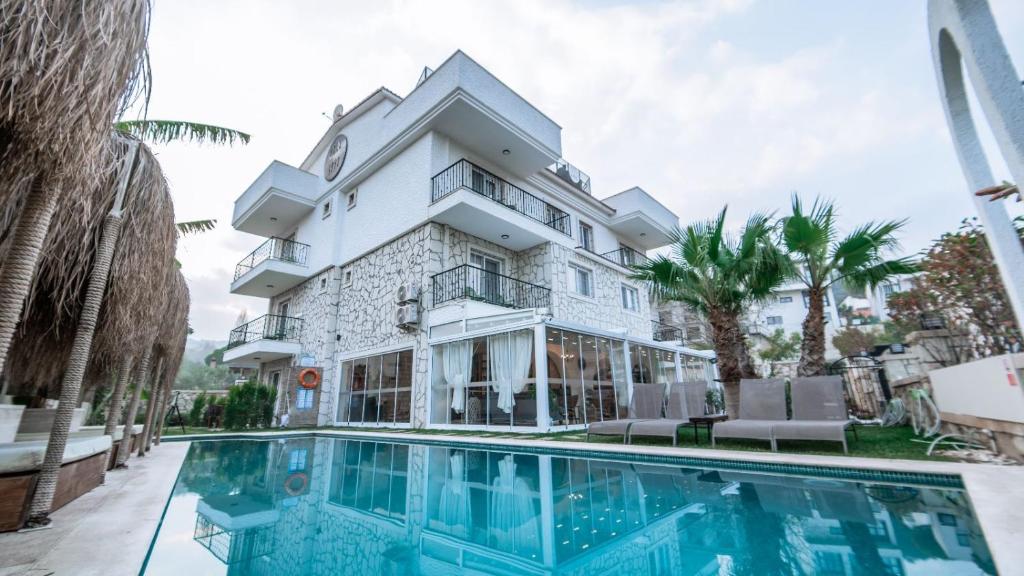 an exterior view of a building with a swimming pool at Urla 1867 Hotel in Ildır