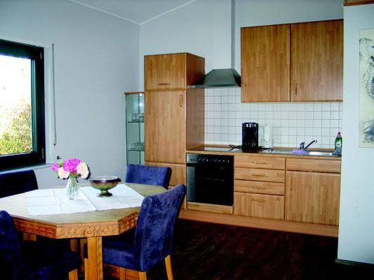 a kitchen with a table with blue chairs and a table sidx sidx sidx at Wiesenhof in Orscholz