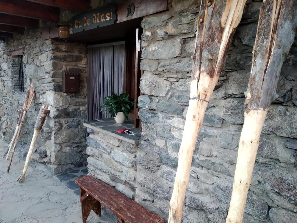 ein Steingebäude mit einer Bank davor in der Unterkunft Ca de Blasi in Taull