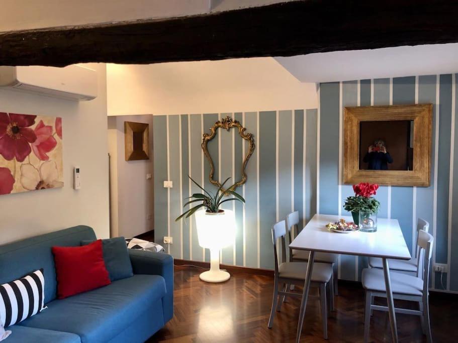 uma sala de estar com um sofá azul e uma mesa em Mini suite del borgo antico em Novi Ligure