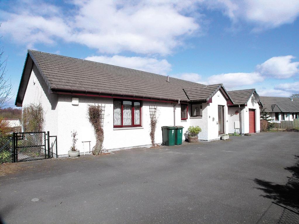 a white house with a black roof and a driveway at Shielgreen in Blairgowrie