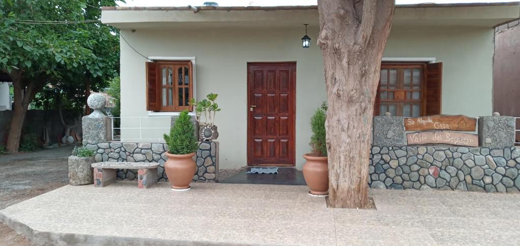 una casa con dos puertas y un banco y plantas en Casa Valle del Bermejo en Villa Unión