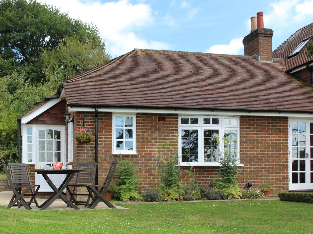 a red brick house with a picnic table in front of it at Castle House Cottage in Horton