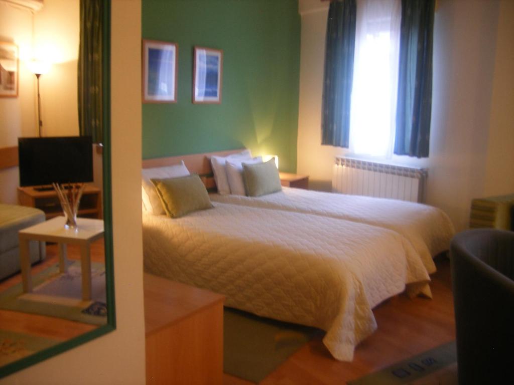 ein Schlafzimmer mit einem großen Bett und einem Fenster in der Unterkunft Hotel 7 in Skopje