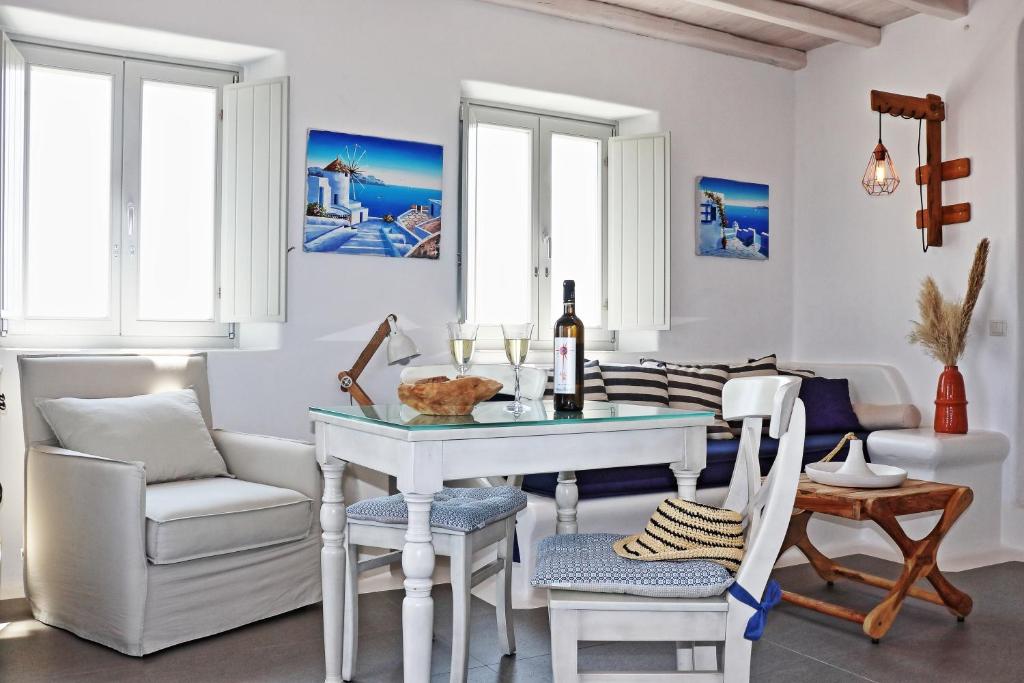 a white dining room with a table and chairs at Antheia Suite of Mykonos in Ano Mera
