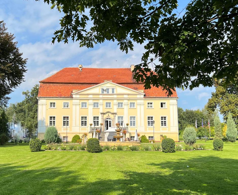 una gran casa blanca con techo rojo en Pałac Henryków, en Szprotawa