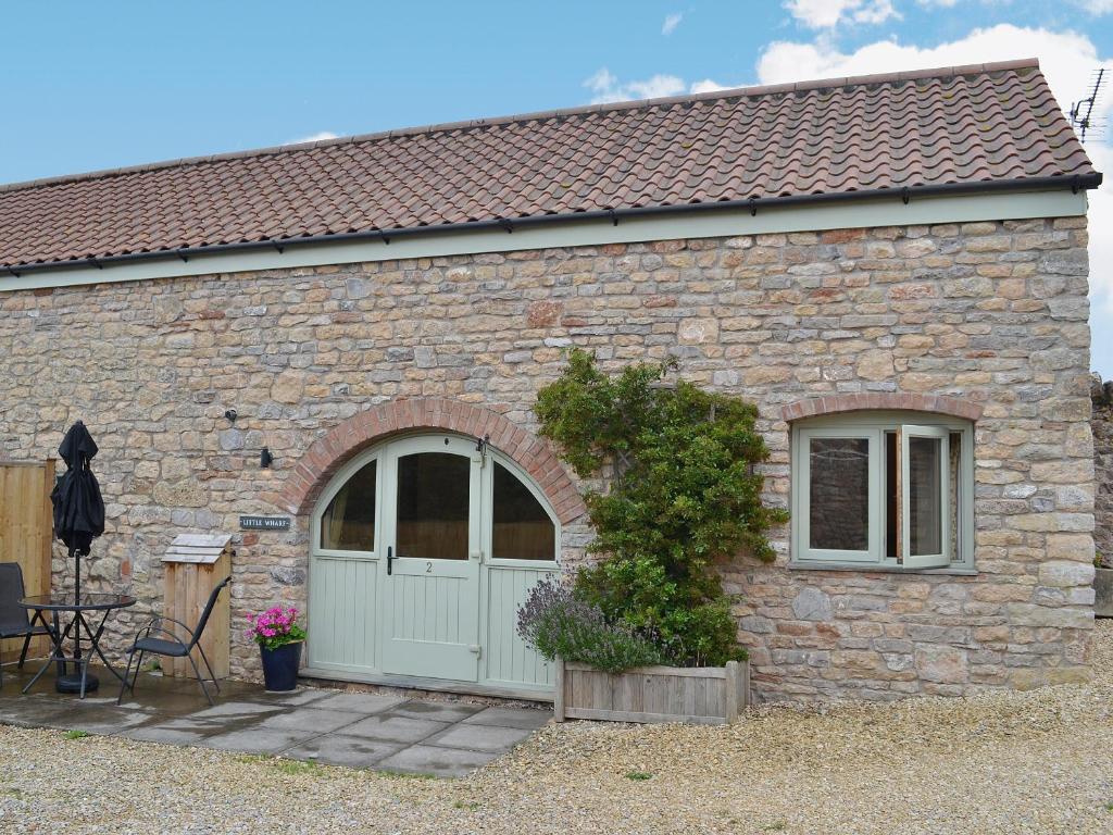 a brick building with a white door and a window at Little Wharf in Loxton