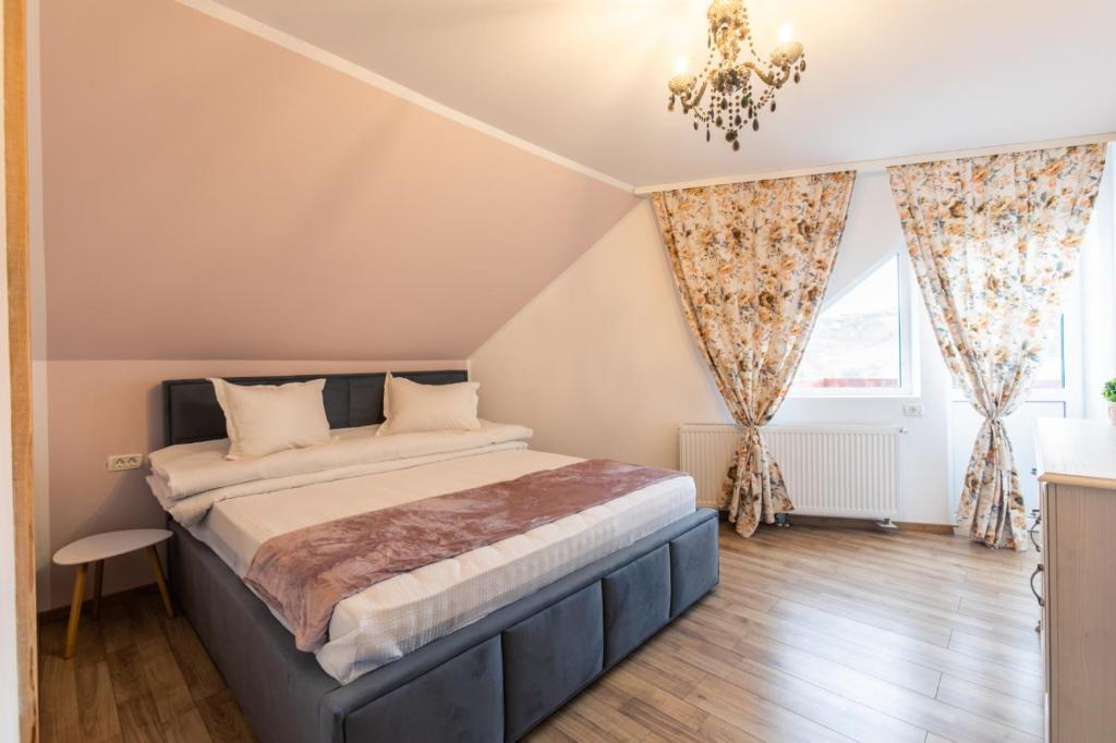 a bedroom with a large bed and a chandelier at On the Hill in Braşov