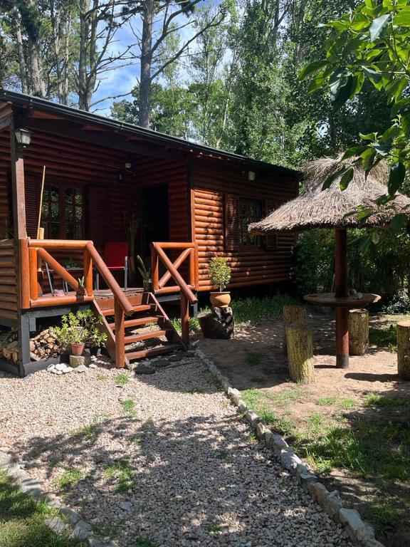 Cabaña de madera con porche y techo de paja en Cabañas mateo en Balneario Mar Azul