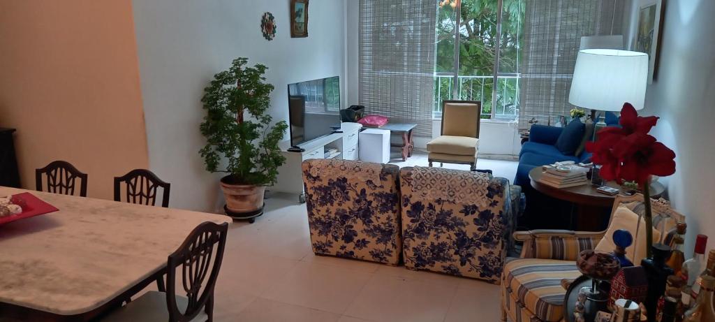 ein Wohnzimmer mit einem Tisch und Stühlen in der Unterkunft Coração de Ipanema in Rio de Janeiro