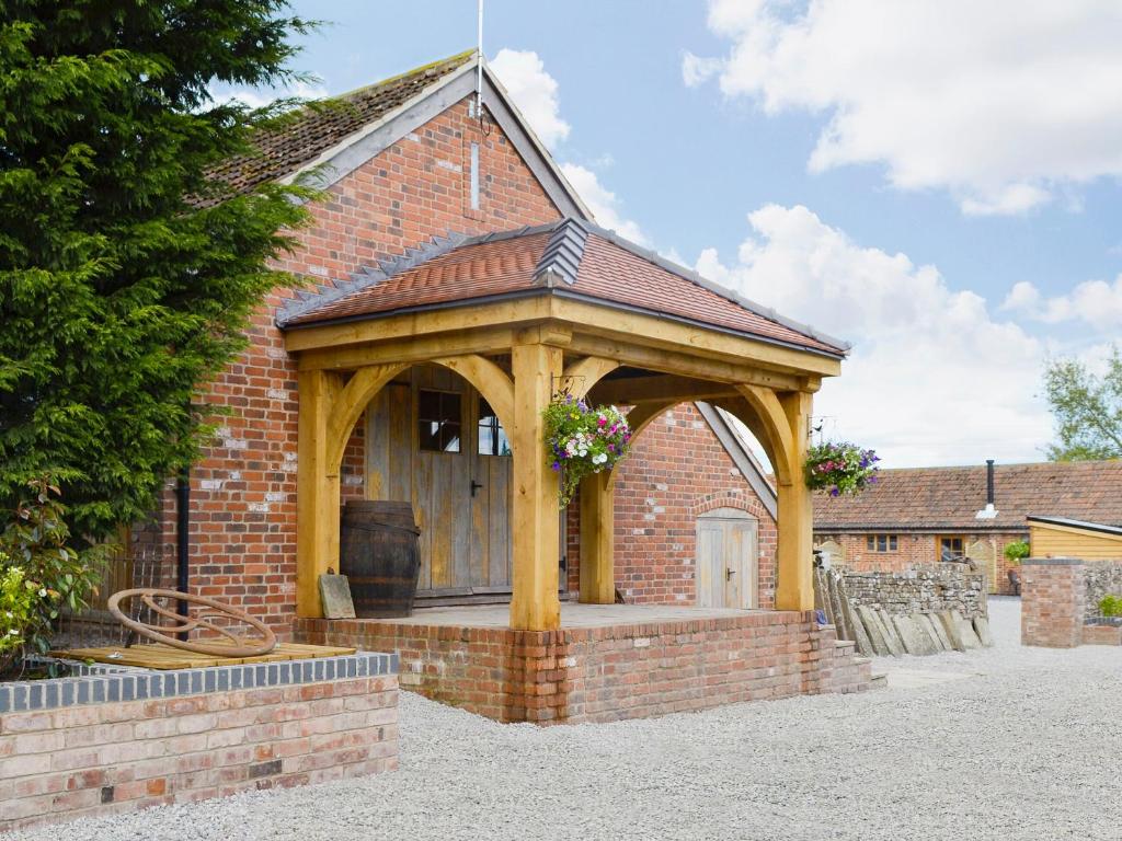 a gazebo on the side of a brick building at The Waggon House in Arlingham