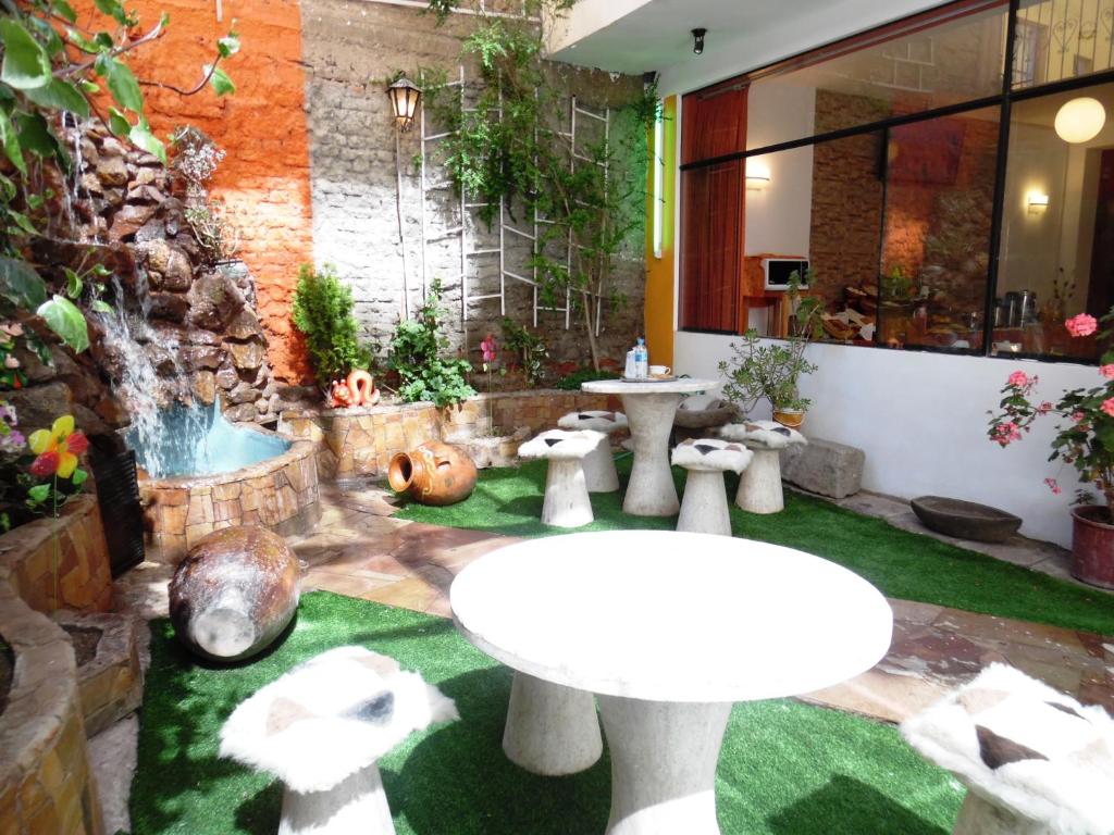 a garden with a table and a water fountain at Hotel Puno Terra in Puno