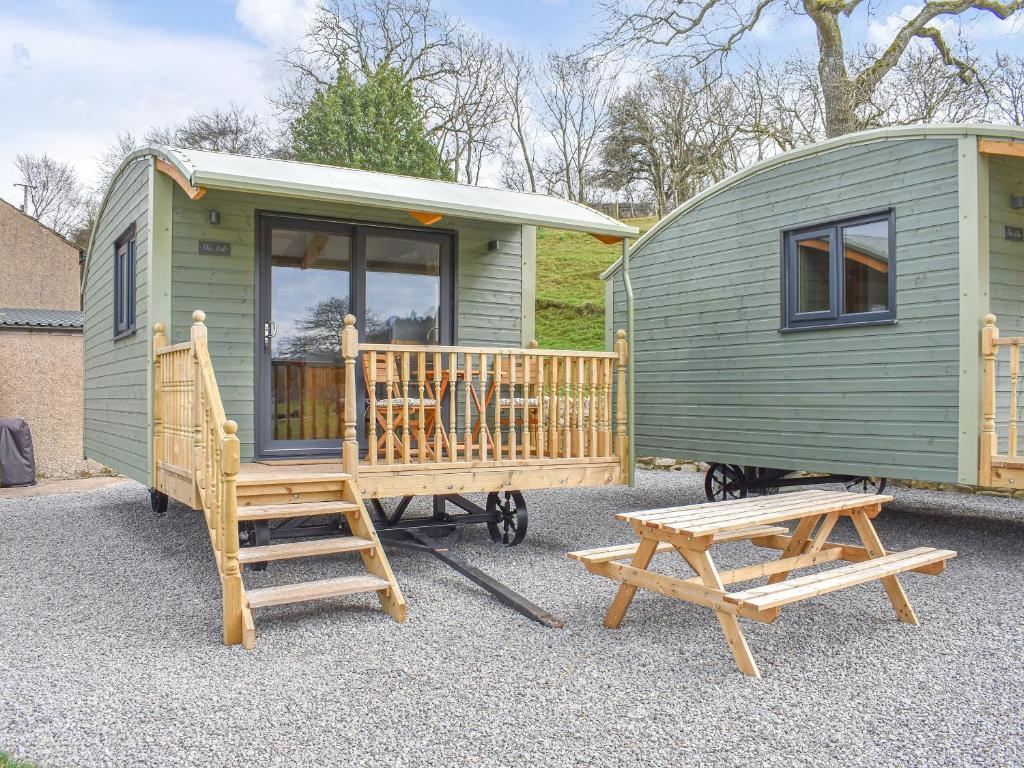 a green tiny house with a bench and a table at The Ash Uk38291 in Crosby Garrett