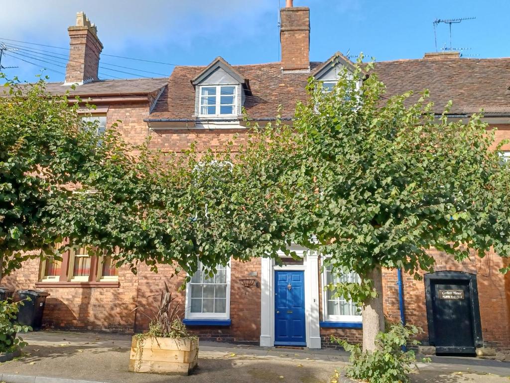 a brick house with a tree in front of it at Ellinor House in Cleobury Mortimer