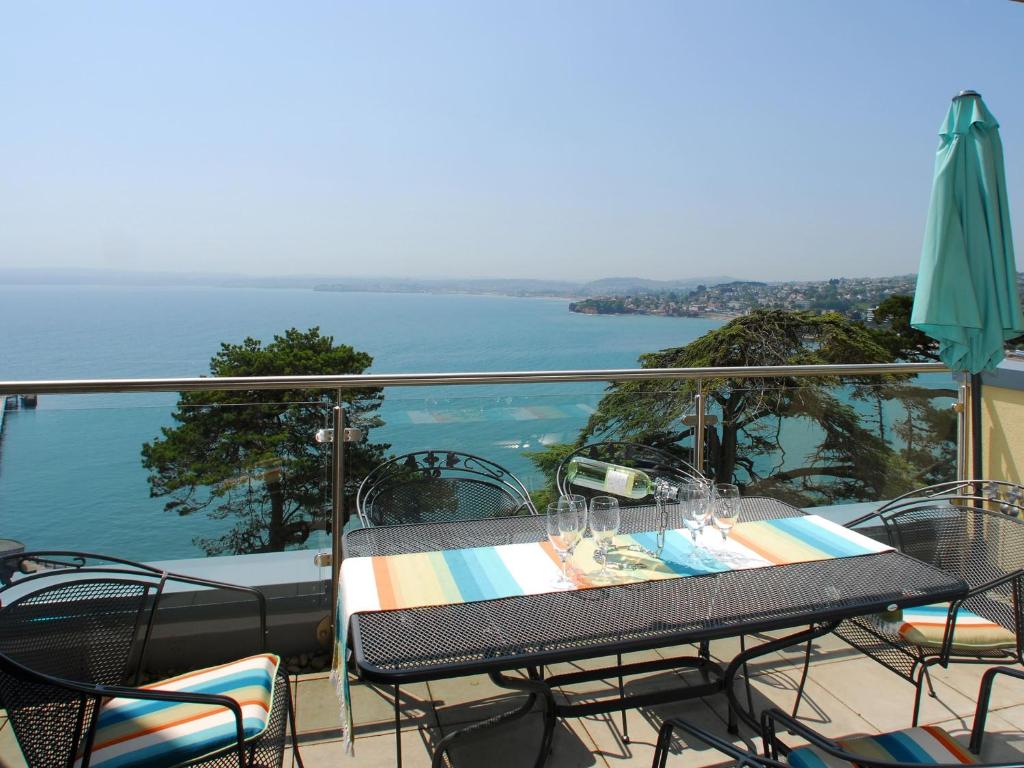 a balcony with a table and chairs and an umbrella at Tree Tops - A4 Masts in Torquay