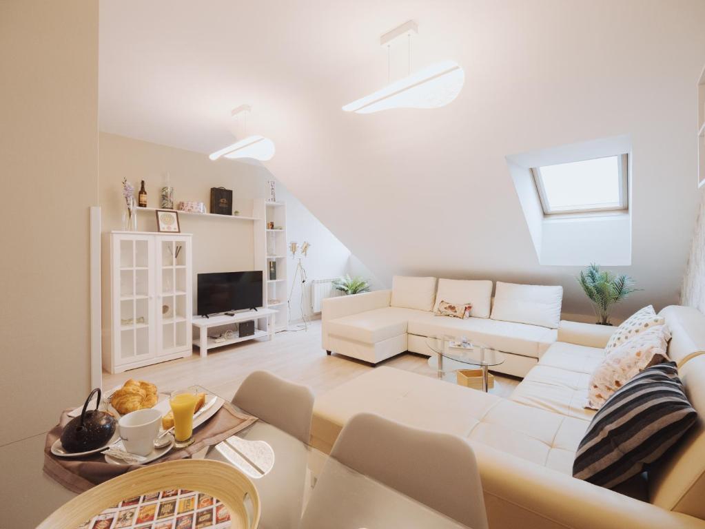 a living room with a white couch and a table at Apartamento SOFIA in Tordesillas