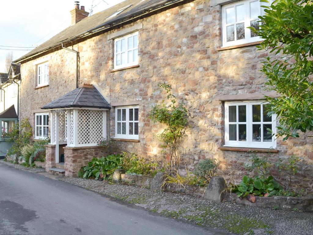 an old brick house with a white window at Riverside Cottage in Washford