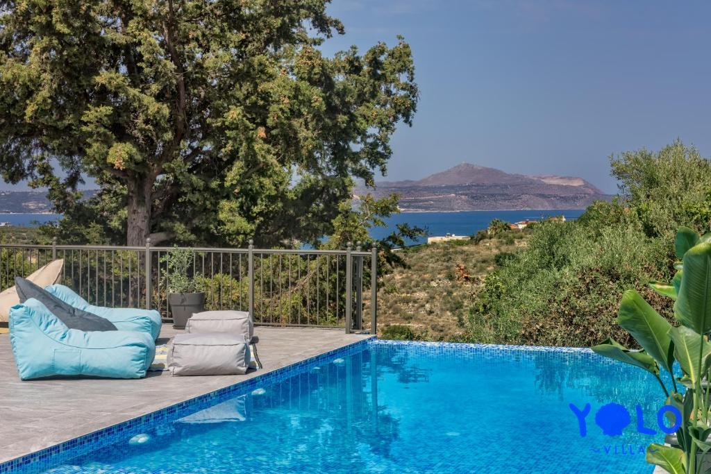 una piscina con 2 tumbonas junto a una piscina en Villa YOLO, en Almyrida