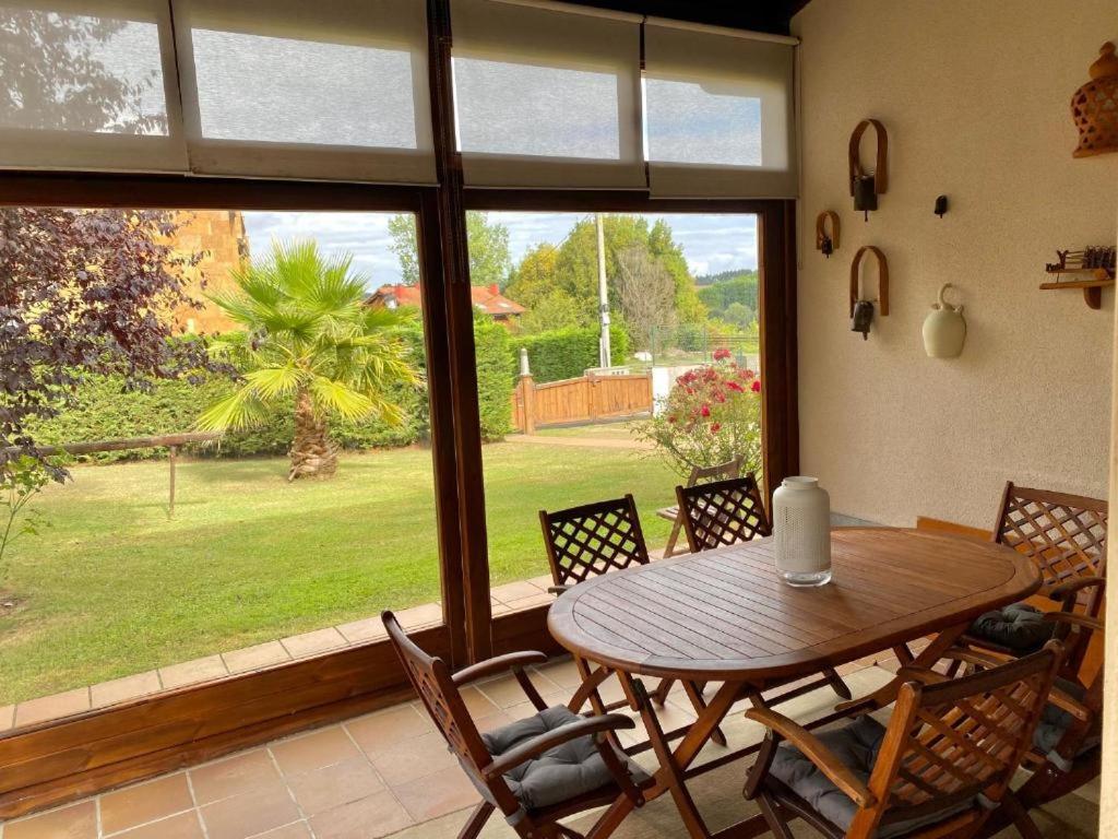 Noriega的住宿－Casona La Teja en Ribadedeva，配有大窗户的客房内的桌椅