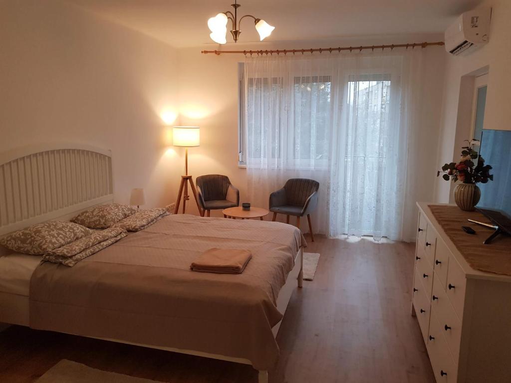 a bedroom with a bed and a desk and a window at Kislakás Esztergomban in Esztergom