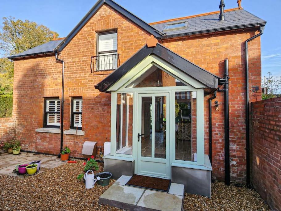 an extension to a brick house with a door at Cosy 2 Bedroom Coach House in Belfast