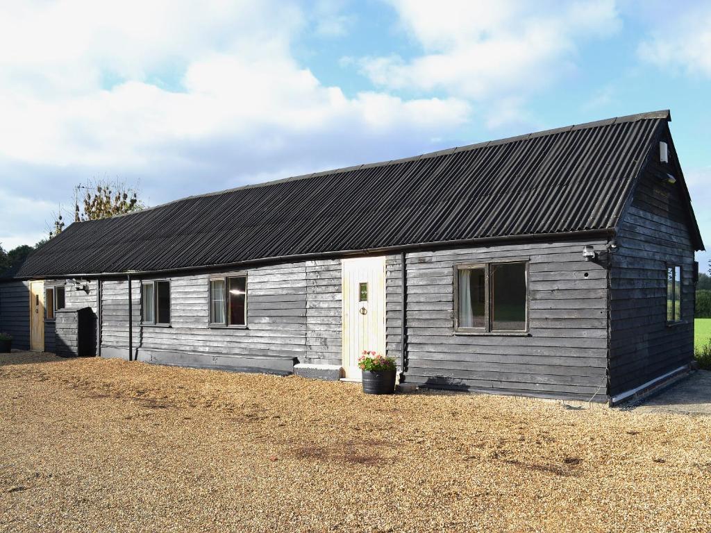 a small wooden house with a black roof at The Old Calf House in Little Baddow