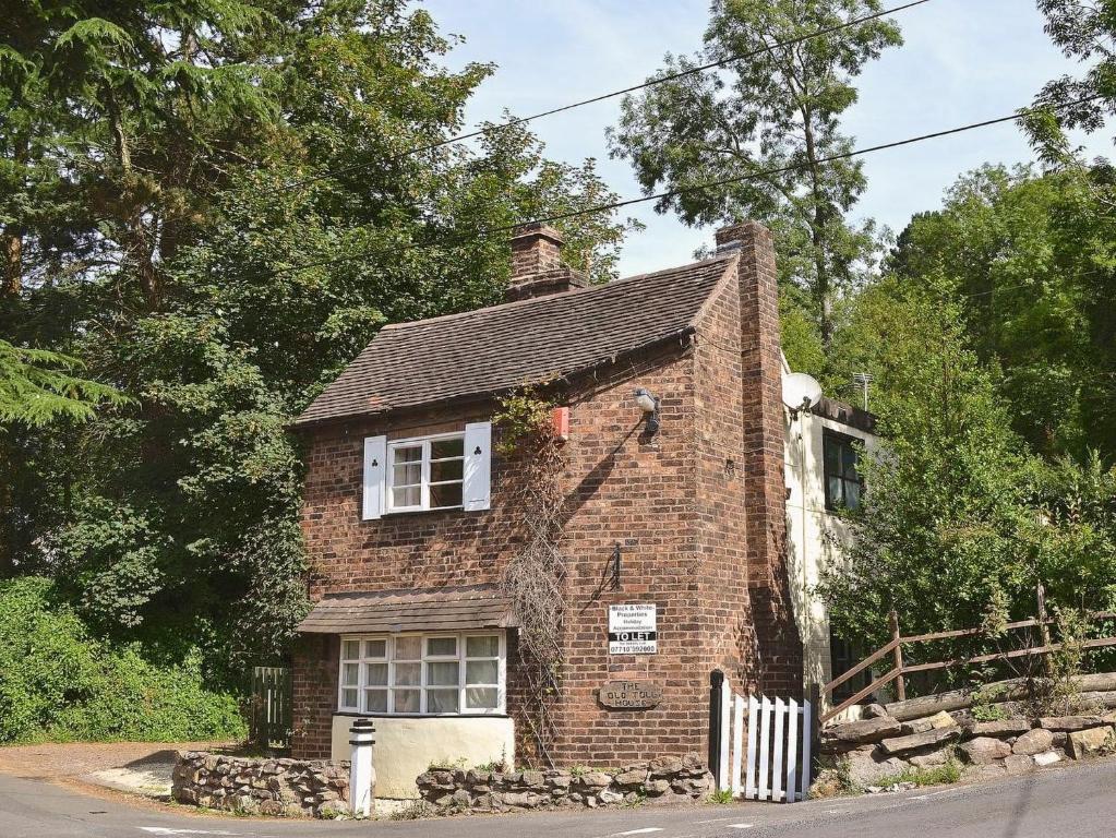 an old brick house is sitting on the side of the road at The Old Toll House in Coalport