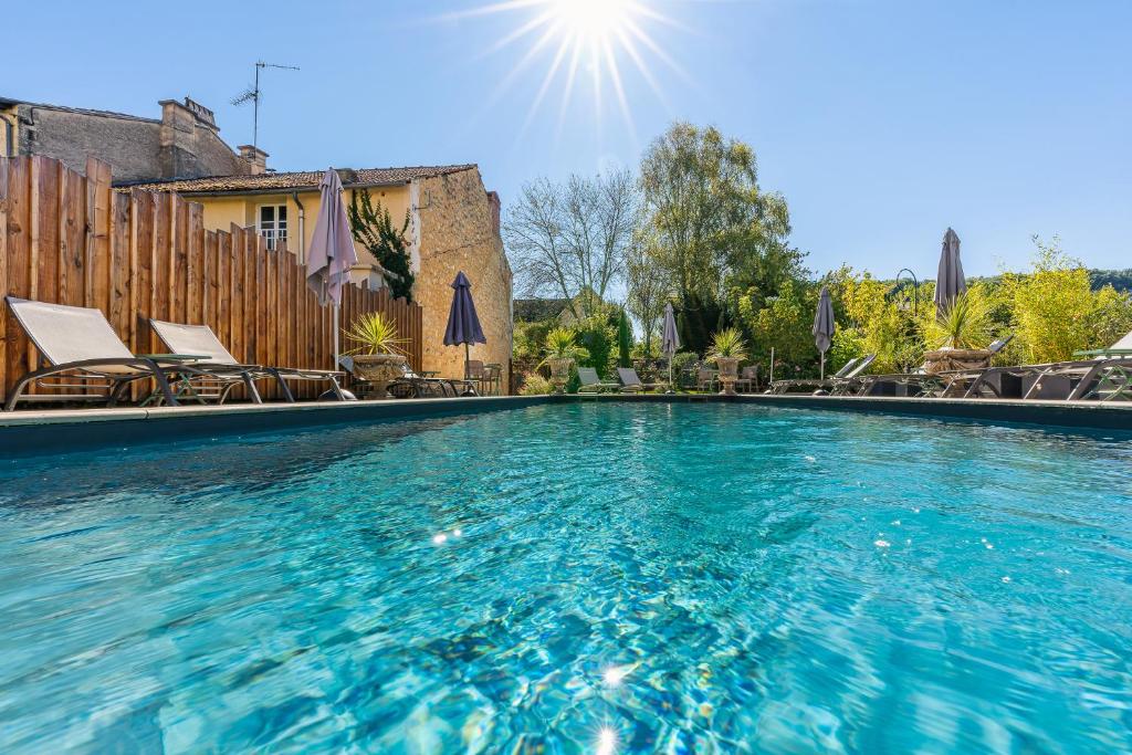 una gran piscina de agua azul en La Villa du 15 - Chambres indépendantes & autonomes du restaurant La Maison - clim et piscine chauffée - Lit King Size, en Les Eyzies-de-Tayac