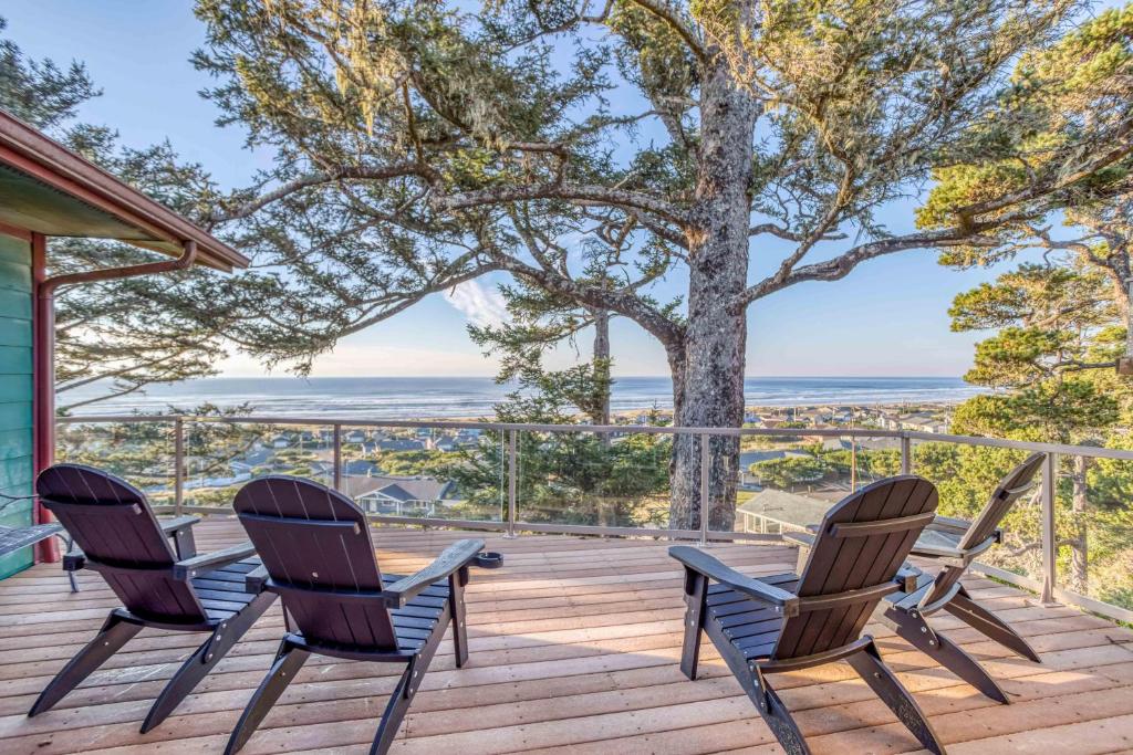 une terrasse avec des chaises, une table et un arbre dans l'établissement Pacific Ocean Blue, à Waldport