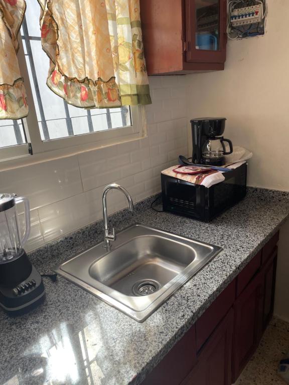 a kitchen counter with a sink and a coffee maker at Cristian suit in Ensanche Savica de Mendoza