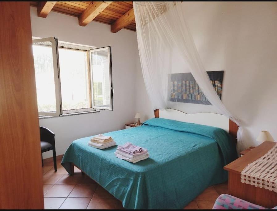 a bedroom with a blue bed with two towels on it at Il Nido di Mortelle II in Messina