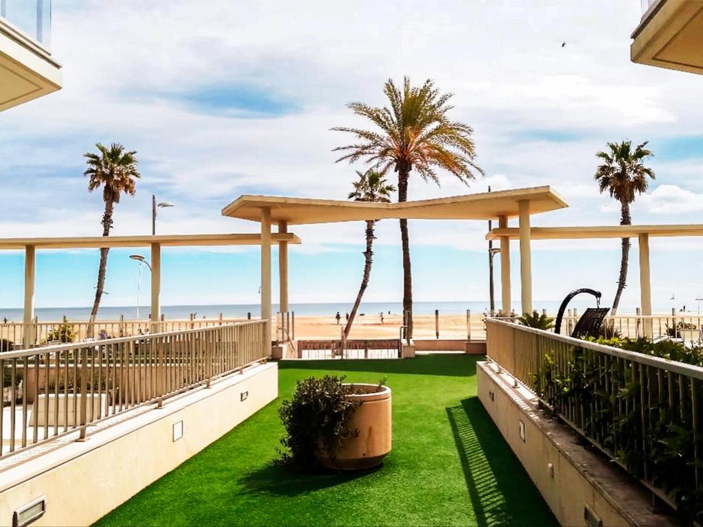 einen Balkon mit Blick auf den Strand und Palmen in der Unterkunft Anka Beach Apartment Patacona in Valencia