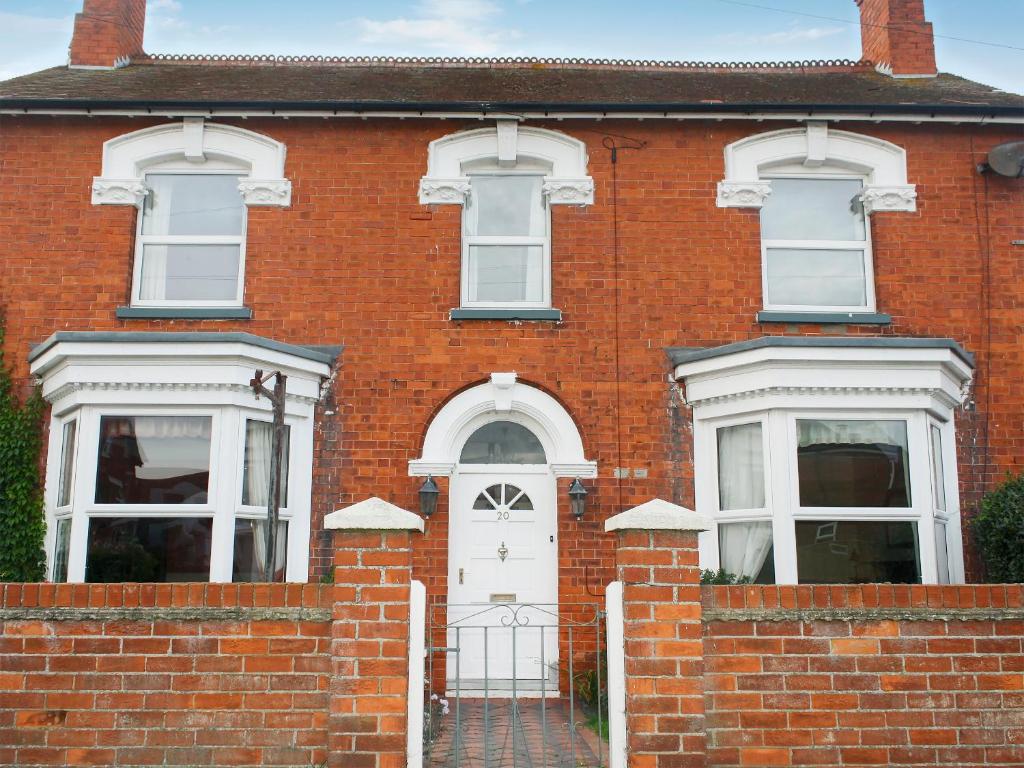 a red brick house with a white door at Twenty in Sutton on Sea