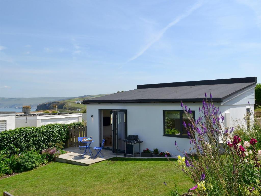 a small white house with a grass yard at Bosuns in Port Isaac