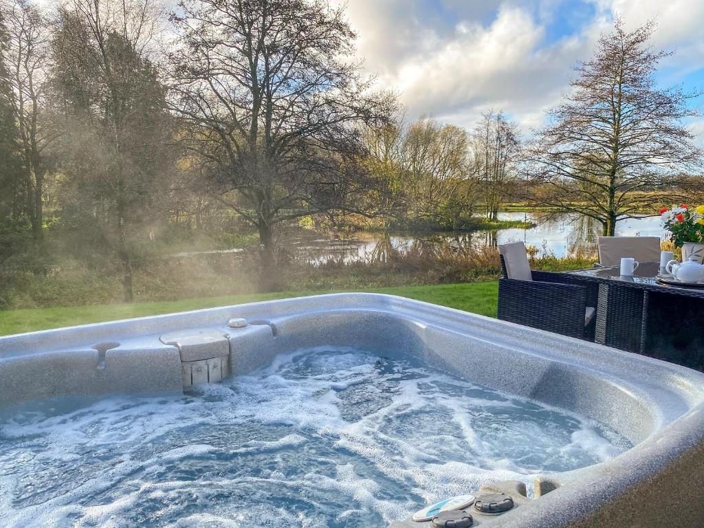a jacuzzi tub in a backyard with a view at Wren Cottage in Llandeilo