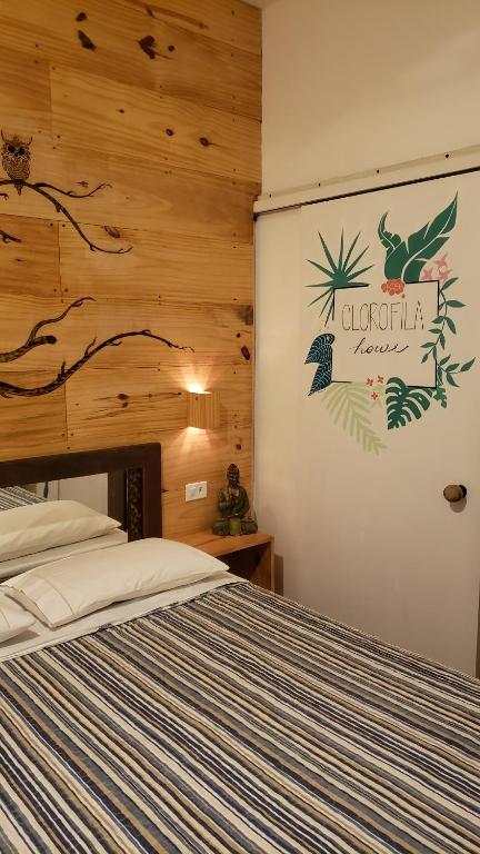 - une chambre avec un lit et un panneau mural dans l'établissement Suite Clorofila House Guest House, à Ubatuba