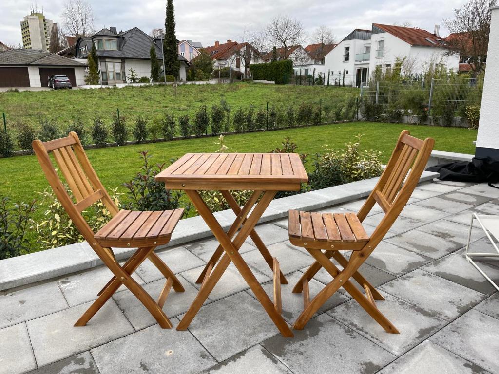 een houten tafel en twee stoelen naast een tafel bij Traumhaft helle Wohnung mit Sonnenterrasse in Worms