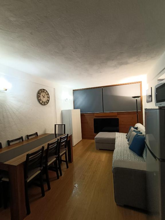 een woonkamer met een tafel en een groot scherm bij Appartement la Plagne,7 pers rénové in Aime La Plagne