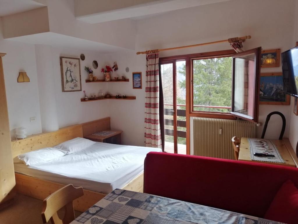 - une petite chambre avec un lit et une fenêtre dans l'établissement Tana delle Marmotte, à Falcade
