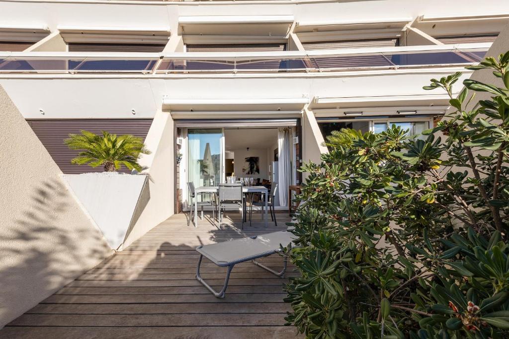 a balcony of a house with a table and chairs at Village Naturiste R4N - Le Cassis Heliopolis Luxe in Cap d&#39;Agde